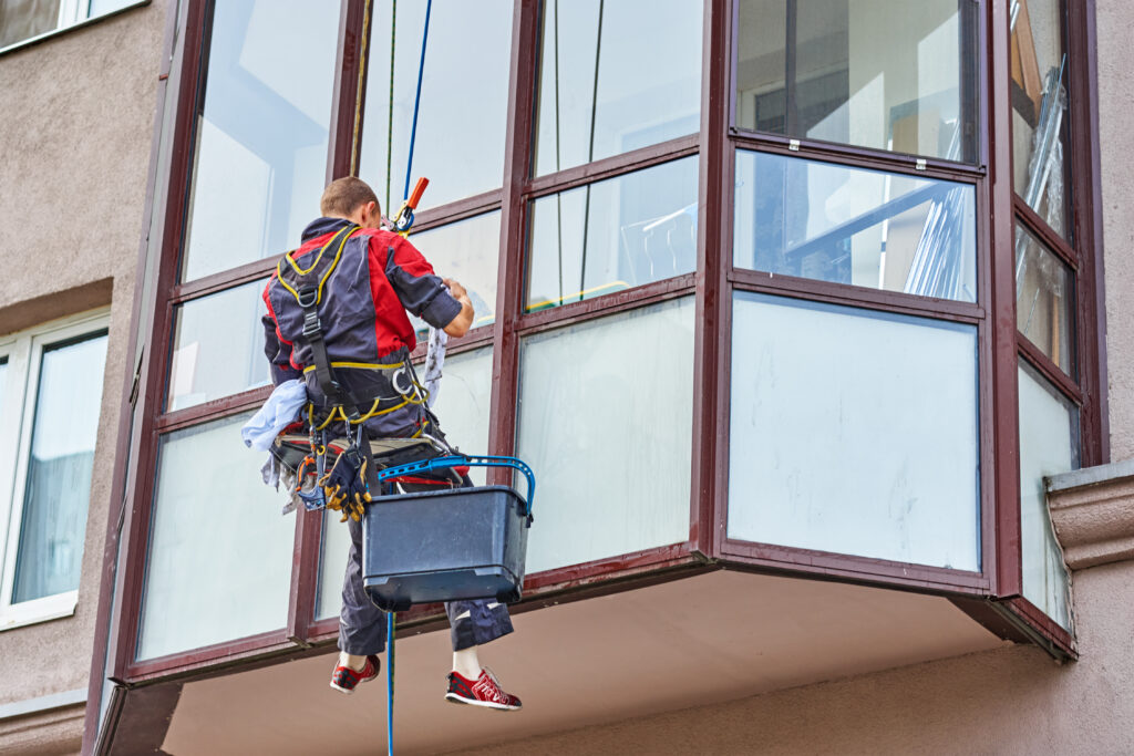 Industrial climber cleaning window on building in the city